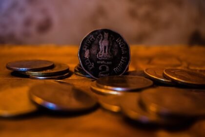 A close-up of indian coins on a wooden surface