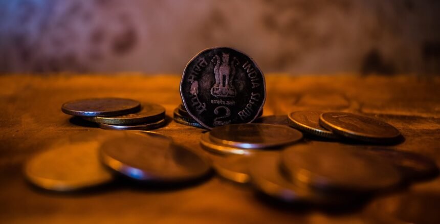 A close-up of indian coins on a wooden surface